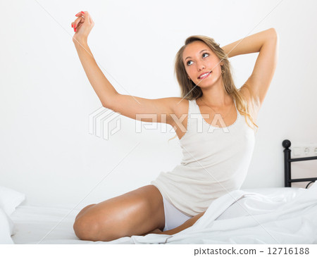 Woman stretching on bed 12716188