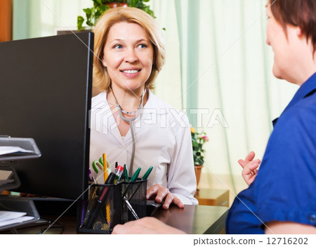 Old doctor having positive news for a person 12716202