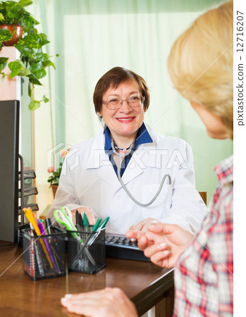 Mature doctor consulting female patient Mature doctor consulting female patient 12716207