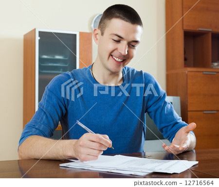 man staring financial documents at table 12716564