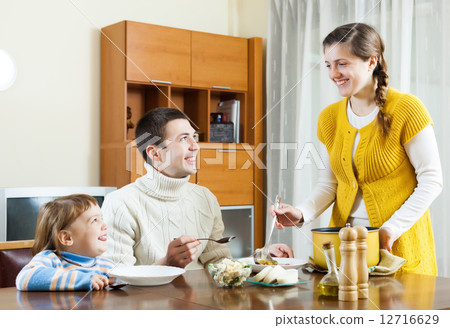 Happy couple with child having lunch 12716629