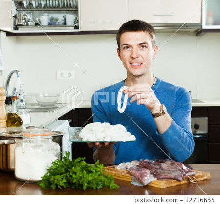 Happy man with raw squid Happy man with raw squid 12716635