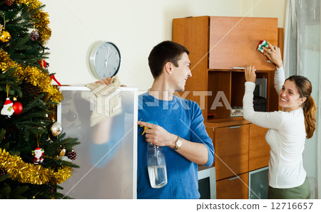 Smiling couple wiping dust 12716657