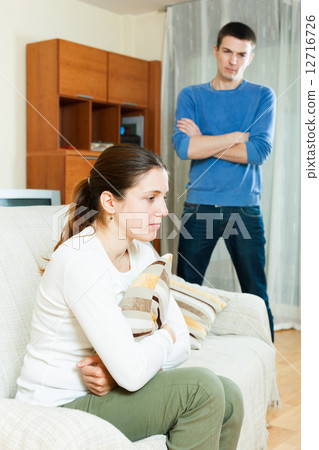 Unhappy woman against standing man 12716726