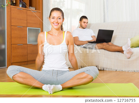 Couple doing yoga with laptop 12716755