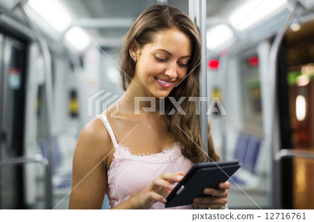 Woman with ereader in subway train 12716761
