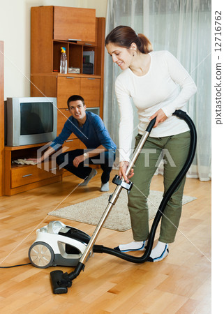 family cleaning with vacuum cleaner in home 12716762