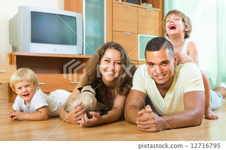 Family of four playing with kitten 12716795