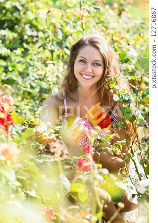 Girl in roses plant at garden Girl in roses plant at garden 12716867