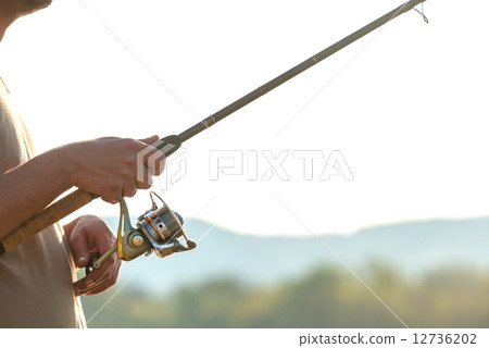 Modern clean fishing rod in hands Modern clean fishing rod in hands 12736202