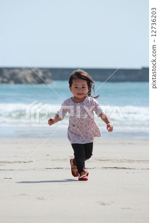 A girl running along the beach A girl running along the beach 12736203