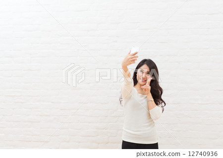 A woman taking self with her smartphone A woman taking self with her smartphone 12740936