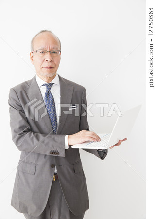 Senior businessman with a PC 12750363