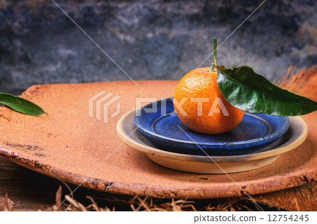 Tangerine on blue plate 12754245