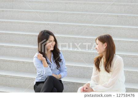 A woman sitting on the stairs and speaking A woman sitting on the stairs and speaking 12758476