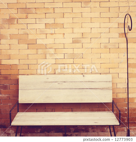 Outdoor wooden chair on brick wall, retro filter effect Outdoor wooden chair on brick wall, retro filter effect 12773903