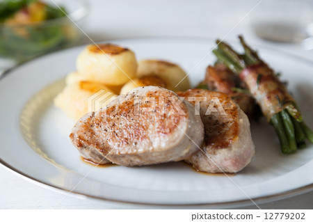 Pork medallions with potatoes and beans 12779202