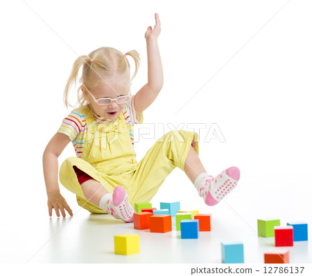 Funny child in eyeglases playing colorful building blocks isolated Funny child in eyeglases playing colorful building blocks isolated 12786137