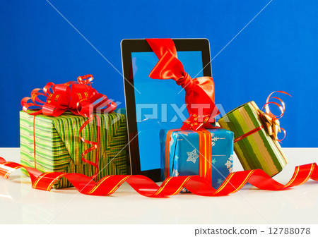 Presents with a tablet pc against blue background 12788078