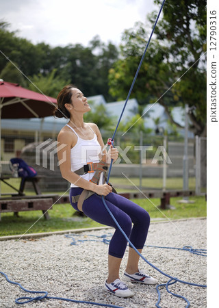 Asian Woman in belaying stance in outdoor rockclimb 12790316