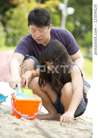 Asian father and daughter playing sand in park 12804829