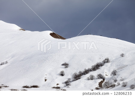 Off piste slope and overcast gray sky in windy day 12806233