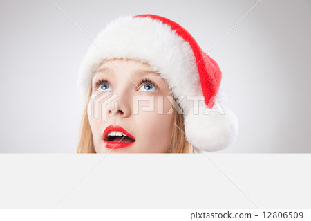 Christmas woman in santa hat holding empty board Christmas woman in santa hat holding empty board 12806509