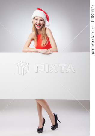 Christmas woman in santa hat holding empty board 12806578