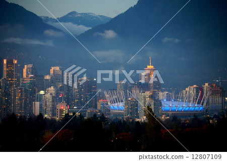 Vancouver city center building and mountain ranges illuminated by the sunset - Vancouver city center of building and mountains illuminated by the sun 12807109