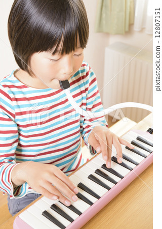 A girl playing a keyboard harmonica A girl playing a keyboard harmonica 12807151