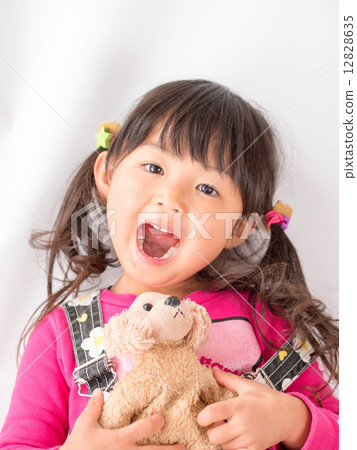 A girl with a smile with a doll 12828635