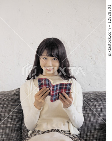 A woman reading a book on a sofa A woman reading a book on a sofa 12828801