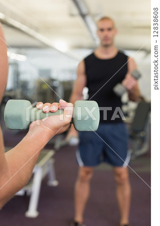 Blurred man exercising with dumbbell in gym Blurred man exercising with dumbbell in gym 12838608