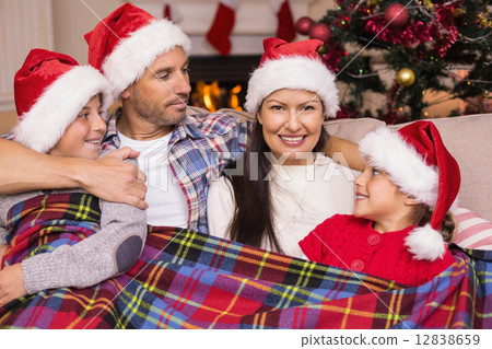 Festive family in santa hat hugging under the cover Festive family in santa hat hugging under the cover 12838659