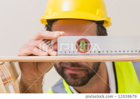 Construction worker using spirit level 12838679