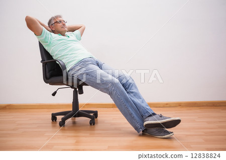 Mature man leaning back in swivel chair Mature man leaning back in swivel chair 12838824