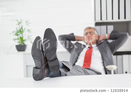 Relaxed businessman with his feet up 12838914