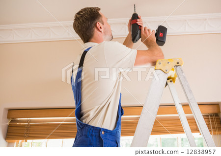 Handyman using a cordless drill to the ceiling Handyman using a cordless drill to the ceiling 12838957