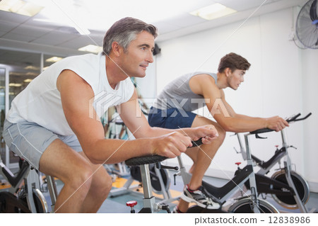 Fit people working out on the exercise bikes 12838986