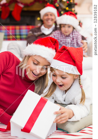 Surprised mother and daughter opening a christmas gift Surprised mother and daughter opening a christmas gift 12839102