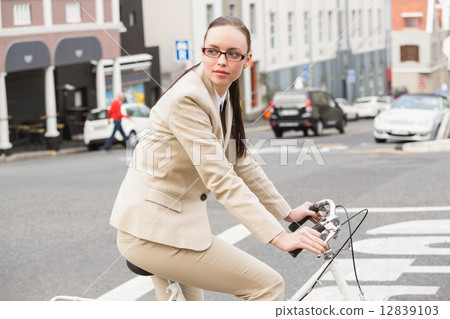 Young businesswoman riding her bike Young businesswoman riding her bike 12839103