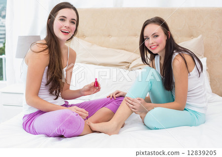Pretty brunette painting her friends nails Pretty brunette painting her friends nails 12839205