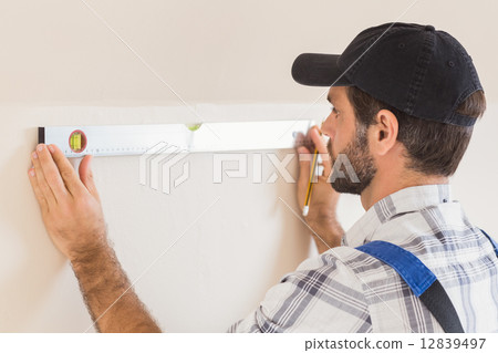 Construction worker using spirit level 12839497