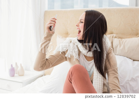 Angry brunette shouting at her phone 12839702