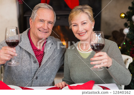 Couple toasting to the camera with red wine Couple toasting to the camera with red wine 12840162