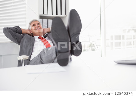 Relaxed businessman with his feet up 12840374