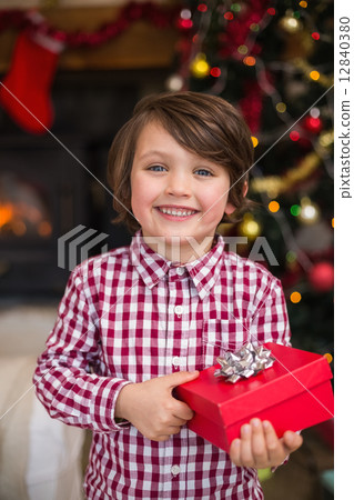 Festive little boy holding a gift Festive little boy holding a gift 12840380