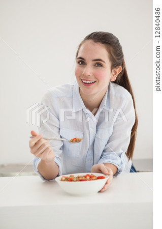 Pretty brunette eating bowl of cereal 12840486