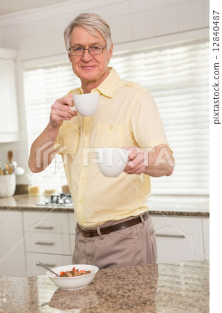 Senior man offering cup to camera 12840487