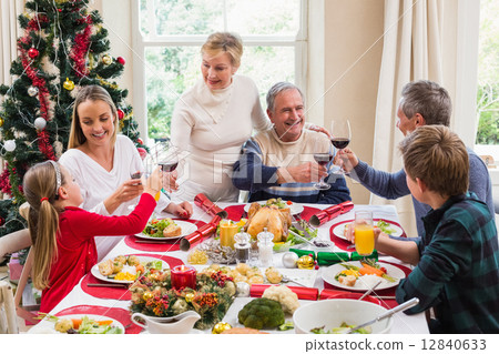 Family toasting with red wine in a christmas dinner